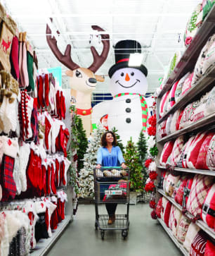 Image of a woman strolling down a corridor full of Christmas items