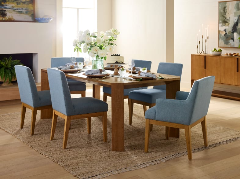 Cotswold Lane dining room with wood dining table, blue chairs, and a styled sideboard